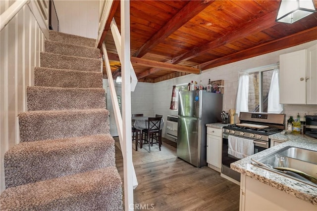 423 Forest Ln, Crestline, CA 92325 - kitchen with appliances with stainless steel finishes, wooden ceiling with exposed beams, wood finished floors, white cabinetry, and heating unit