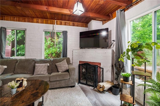423 Forest Ln, Crestline, CA 92325 - living area featuring wooden ceiling with exposed beams, wood finished floors, plenty of natural light, and a fireplace