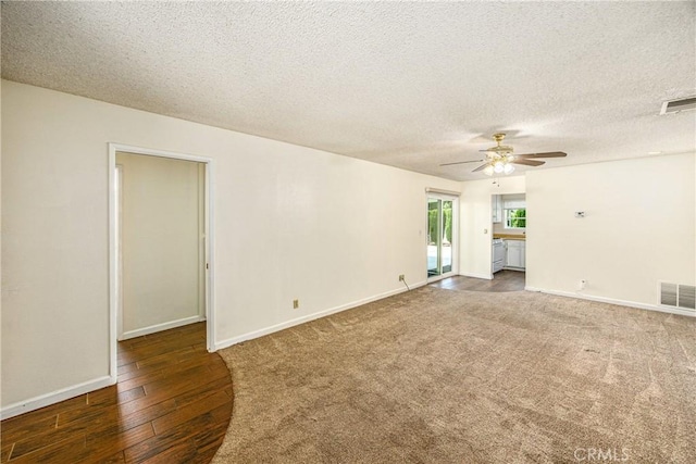 5406 Ellen Way, Banning, CA 92220 - unfurnished living room with ceiling fan, a textured ceiling, baseboards, hardwood / wood-style floors, and carpet flooring