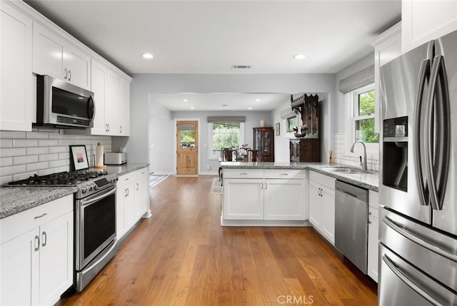 1526 Garden St, San Luis Obispo, CA 93401 - kitchen featuring appliances with stainless steel finishes, a peninsula, plenty of natural light, decorative backsplash, and recessed lighting
