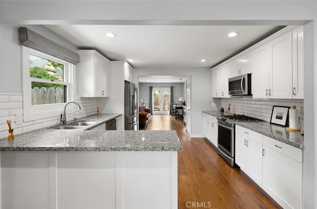 1526 Garden St, San Luis Obispo, CA 93401 - kitchen featuring appliances with stainless steel finishes, light stone countertops, white cabinetry, tasteful backsplash, and recessed lighting