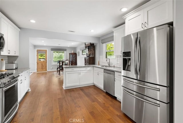 1526 Garden St, San Luis Obispo, CA 93401 - kitchen with appliances with stainless steel finishes, a peninsula, tasteful backsplash, white cabinetry, and recessed lighting