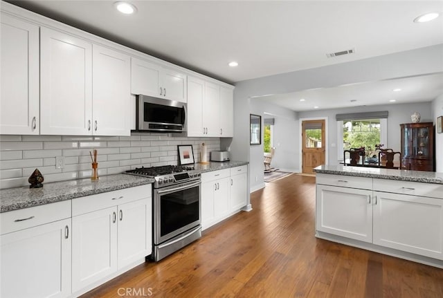 1526 Garden St, San Luis Obispo, CA 93401 - kitchen featuring appliances with stainless steel finishes, backsplash, dark wood-style flooring, white cabinets, and recessed lighting