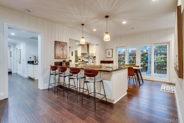 1530 Stewart St, Oceanside, CA 92054 - kitchen featuring a kitchen bar, a peninsula, dark wood-style flooring, dark countertops, and pendant lighting