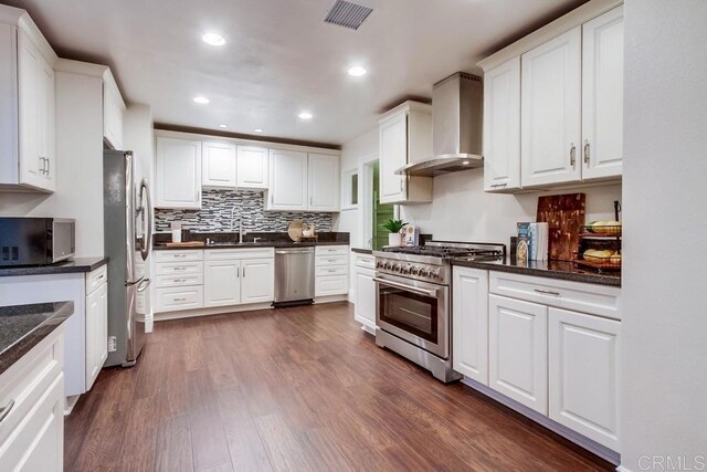 1530 Stewart St, Oceanside, CA 92054 - kitchen with stainless steel appliances, wall chimney exhaust hood, a sink, white cabinets, and dark wood-style floors