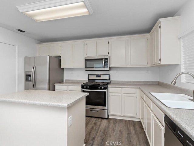 26230 Monticello Way, Murrieta, CA 92563 - kitchen with stainless steel appliances, a sink, dark wood-style flooring, white cabinets, and light countertops