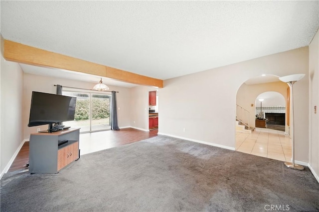 918 Sequoia Ct, San Dimas, CA 91773 - unfurnished living room featuring carpet floors, arched walkways, baseboards, and stairs