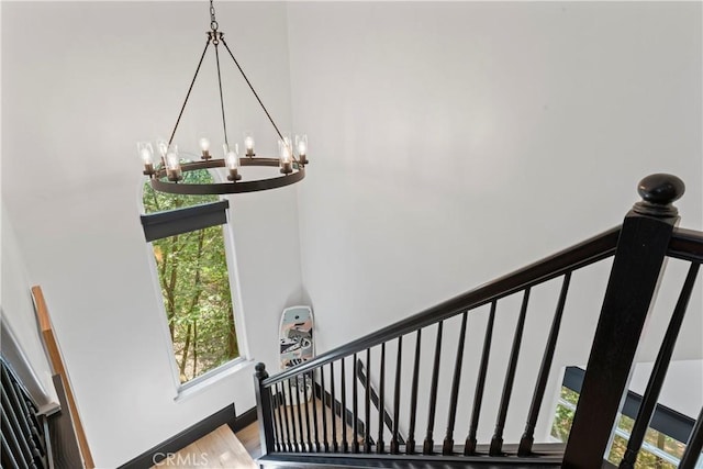 1019 Pintail Cir, Lake Arrowhead, CA 92352 - stairway featuring a chandelier, wood finished floors, and a high ceiling