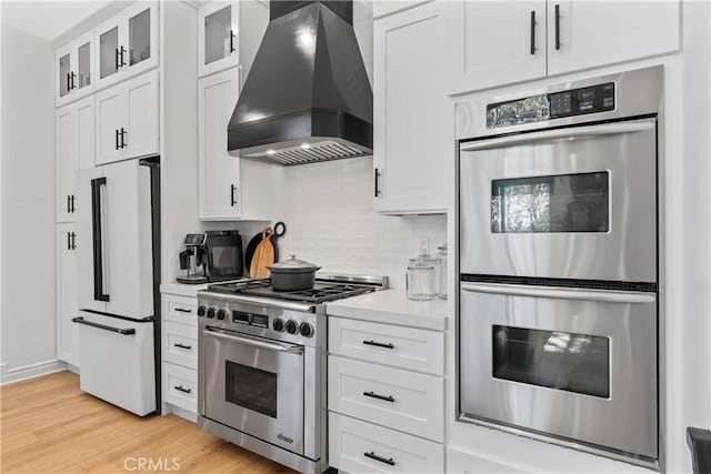 1019 Pintail Cir, Lake Arrowhead, CA 92352 - kitchen with high quality appliances, custom exhaust hood, light countertops, tasteful backsplash, and light wood-type flooring