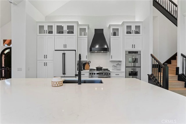 1019 Pintail Cir, Lake Arrowhead, CA 92352 - kitchen with custom range hood, appliances with stainless steel finishes, white cabinets, backsplash, and lofted ceiling