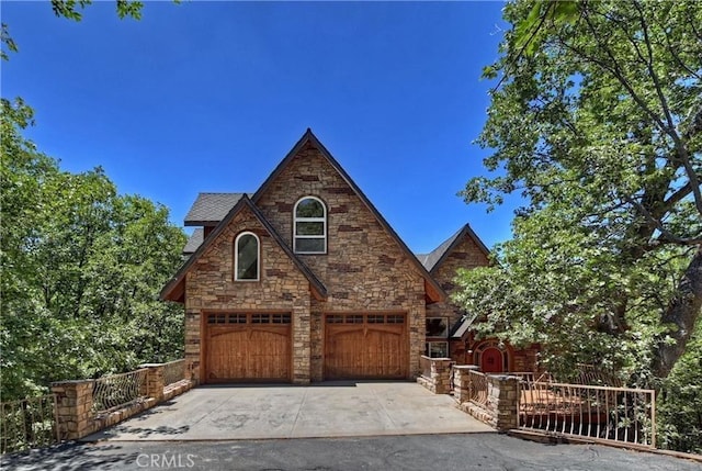 1019 Pintail Cir, Lake Arrowhead, CA 92352 - tudor house with stone siding, concrete driveway, and a garage
