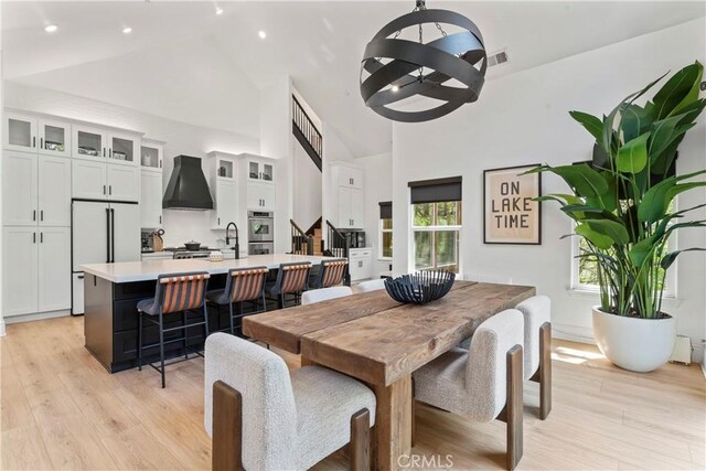 1019 Pintail Cir, Lake Arrowhead, CA 92352 - dining room with high vaulted ceiling, light wood finished floors, recessed lighting, stairs, and a chandelier