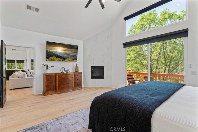 1019 Pintail Cir, Lake Arrowhead, CA 92352 - bedroom with high vaulted ceiling, access to exterior, wood finished floors, a fireplace, and multiple windows