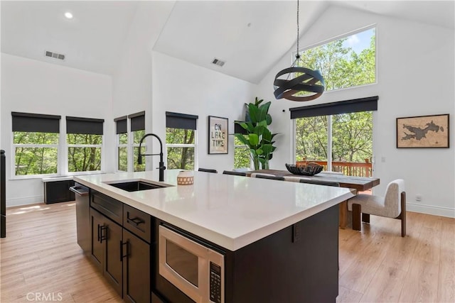 1019 Pintail Cir, Lake Arrowhead, CA 92352 - kitchen with stainless steel appliances, high vaulted ceiling, light countertops, an island with sink, and light wood finished floors