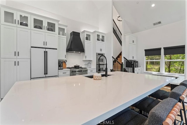 1019 Pintail Cir, Lake Arrowhead, CA 92352 - kitchen featuring high quality appliances, custom exhaust hood, white cabinets, a large island with sink, and high vaulted ceiling
