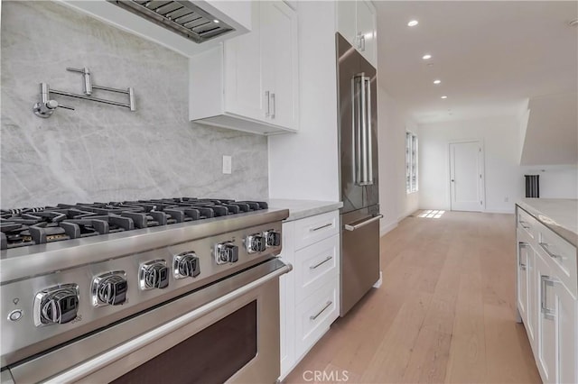 3803 Berryman Ave, Los Angeles, CA 90066 - kitchen with high quality appliances, backsplash, white cabinetry, recessed lighting, and light wood-style floors