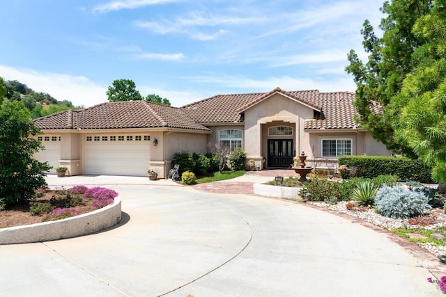 30646 Red Hawk Rd, Valley Center, CA 92082 - mediterranean / spanish-style house with french doors, stucco siding, a garage, concrete driveway, and a tiled roof