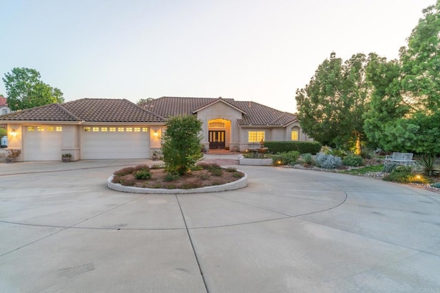 30646 Red Hawk Rd, Valley Center, CA 92082 - mediterranean / spanish house with a tile roof, stucco siding, curved driveway, and a garage