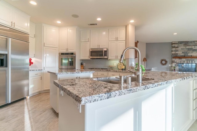 30646 Red Hawk Rd, Valley Center, CA 92082 - kitchen featuring stainless steel appliances, a kitchen island with sink, backsplash, white cabinets, and recessed lighting
