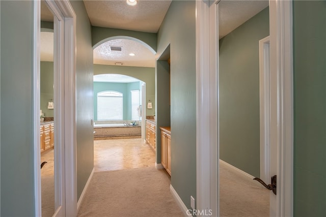 41380 La Sierra Rd, Temecula, CA 92591 - hall featuring light carpet, arched walkways, a textured ceiling, baseboards, and recessed lighting