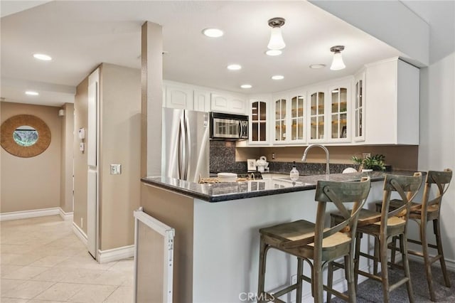 2787 Pine Creek Cir, Fullerton, CA 92835 - kitchen featuring stainless steel appliances, recessed lighting, a peninsula, glass insert cabinets, and a kitchen bar