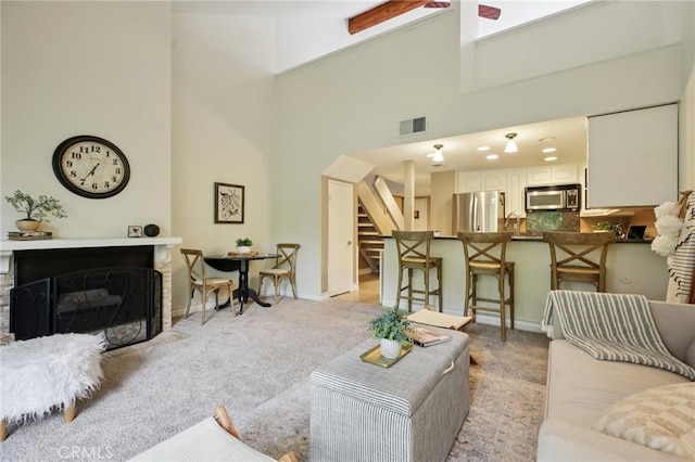 2787 Pine Creek Cir, Fullerton, CA 92835 - living area featuring light carpet, a towering ceiling, stairs, a fireplace with flush hearth, and baseboards