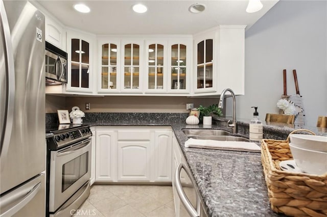 2787 Pine Creek Cir, Fullerton, CA 92835 - kitchen with appliances with stainless steel finishes, a sink, glass insert cabinets, dark stone counters, and light tile patterned floors