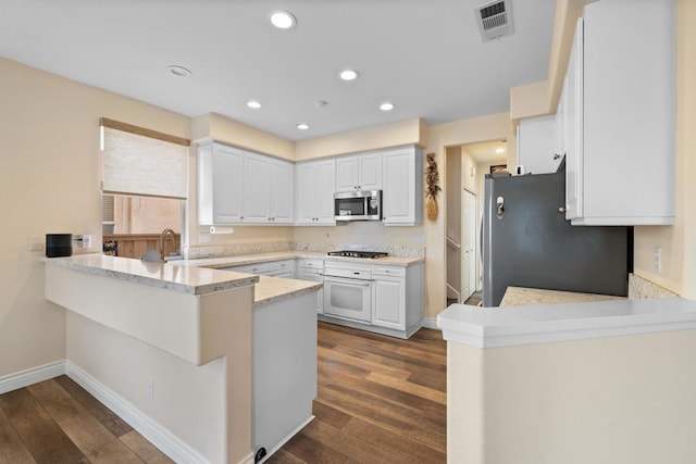11964 Ashley Pl, San Diego, CA 92128 - kitchen featuring stainless steel appliances, a peninsula, dark wood finished floors, white cabinets, and recessed lighting