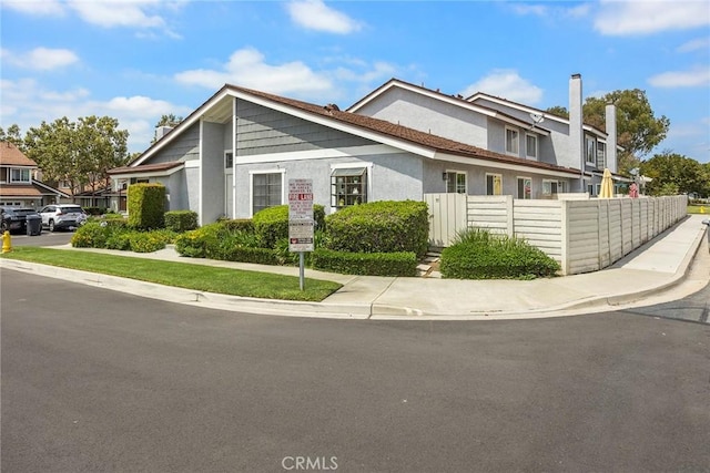 77 S Havenwood Unit 27, Irvine, CA 92614 - view of front facade featuring stucco siding and a chimney