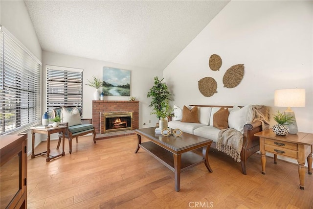 77 S Havenwood Unit 27, Irvine, CA 92614 - living area featuring lofted ceiling, a textured ceiling, a brick fireplace, and light wood-style flooring