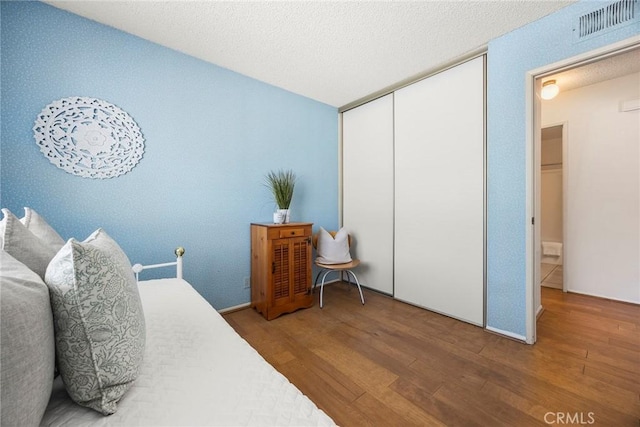 77 S Havenwood Unit 27, Irvine, CA 92614 - bedroom with wood finished floors, a closet, and a textured ceiling