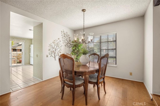 77 S Havenwood Unit 27, Irvine, CA 92614 - dining room featuring a chandelier, wood finished floors, a textured ceiling, and washer / dryer