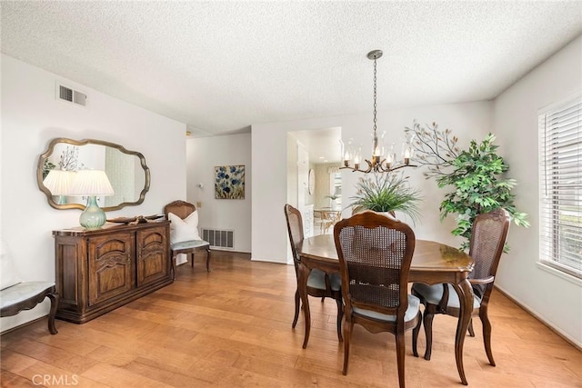 77 S Havenwood Unit 27, Irvine, CA 92614 - dining space with light wood finished floors, a textured ceiling, a chandelier, and plenty of natural light