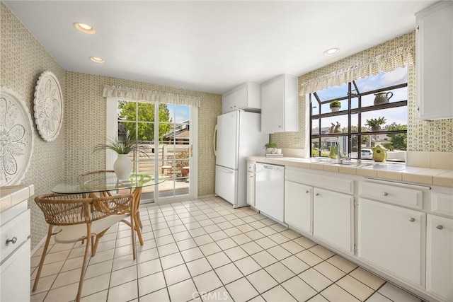77 S Havenwood Unit 27, Irvine, CA 92614 - kitchen with white appliances, wallpapered walls, tile counters, white cabinetry, and recessed lighting
