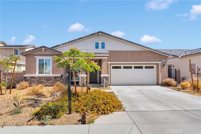 12628 Ojo Caliente St, Victorville, CA 92392 - craftsman house featuring concrete driveway, an attached garage, stone siding, and stucco siding