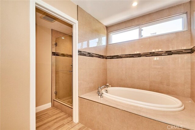2108 Via Caliente, Fullerton, CA 92833 - full bath with a stall shower, a garden tub, plenty of natural light, and wood finished floors