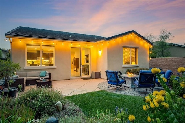 1055 Ford Dr, Nipomo, CA 93444 - back of house at dusk with an outdoor living space with a fire pit, stucco siding, and a patio