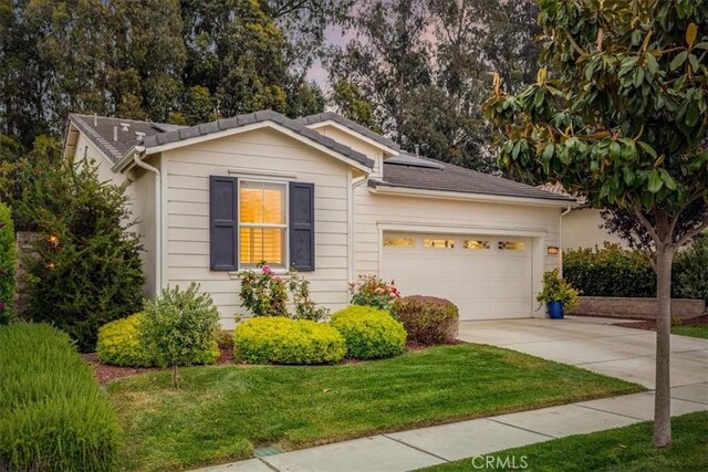 1055 Ford Dr, Nipomo, CA 93444 - ranch-style house featuring driveway, a garage, solar panels, and a front lawn