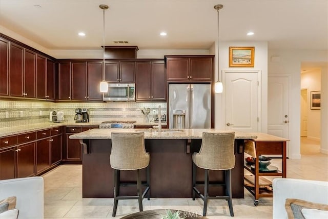 1055 Ford Dr, Nipomo, CA 93444 - kitchen with stainless steel appliances, backsplash, a kitchen island with sink, a breakfast bar, and light stone countertops