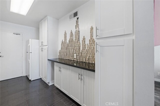 14506 Benefit St Unit 103, Sherman Oaks, CA 91403 - kitchen featuring freestanding refrigerator, white cabinets, dark countertops, and dark wood-style floors