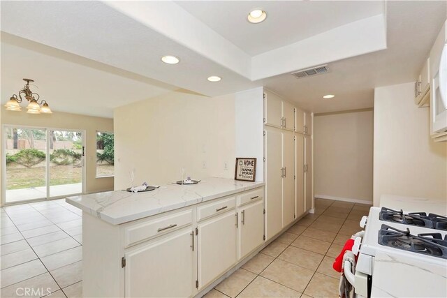 7605 Pasito Ave, Rancho Cucamonga, CA 91730 - kitchen with white gas range, light tile patterned floors, recessed lighting, a peninsula, and white cabinets