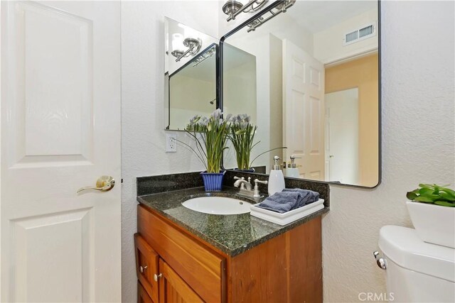 7605 Pasito Ave, Rancho Cucamonga, CA 91730 - half bathroom with vanity, toilet, and a textured wall