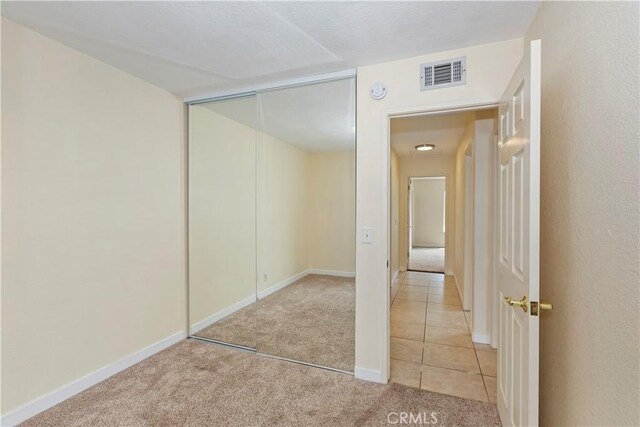 7605 Pasito Ave, Rancho Cucamonga, CA 91730 - unfurnished bedroom featuring light colored carpet, baseboards, a closet, and light tile patterned floors