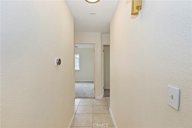 7605 Pasito Ave, Rancho Cucamonga, CA 91730 - corridor with light tile patterned floors, baseboards, light carpet, and a textured wall