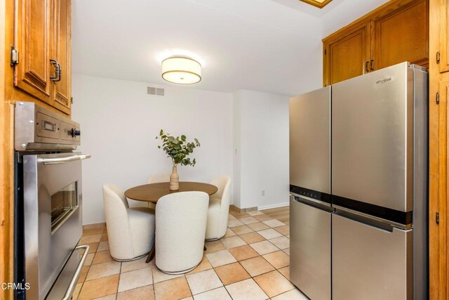 5354 Lindley Ave Unit 202, Encino, CA 91316 - kitchen featuring appliances with stainless steel finishes, brown cabinets, baseboards, and light tile patterned flooring