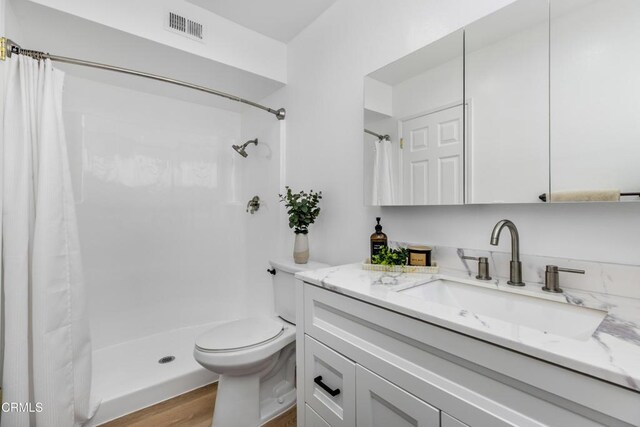 5354 Lindley Ave Unit 202, Encino, CA 91316 - full bathroom featuring vanity, toilet, curtained shower, and wood finished floors