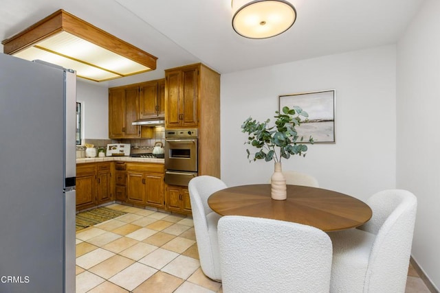 5354 Lindley Ave Unit 202, Encino, CA 91316 - kitchen featuring stainless steel appliances, a warming drawer, under cabinet range hood, tasteful backsplash, and light countertops