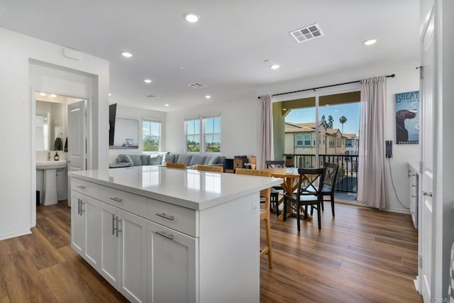 2328 Stardust Gln, Escondido, CA 92025 - kitchen with dark wood finished floors, white cabinetry, a kitchen island, recessed lighting, and light countertops
