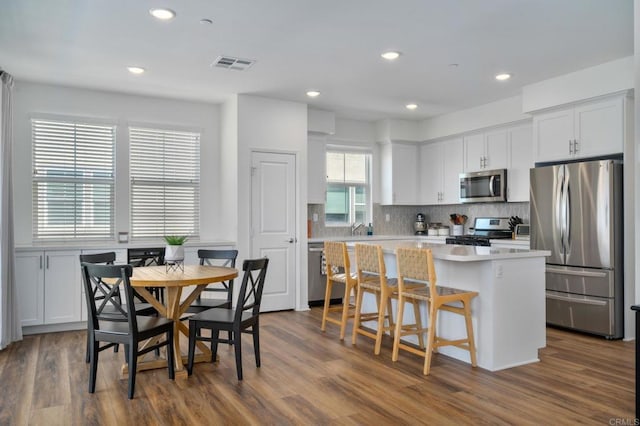 2328 Stardust Gln, Escondido, CA 92025 - kitchen featuring stainless steel appliances, a center island, white cabinetry, tasteful backsplash, and light countertops