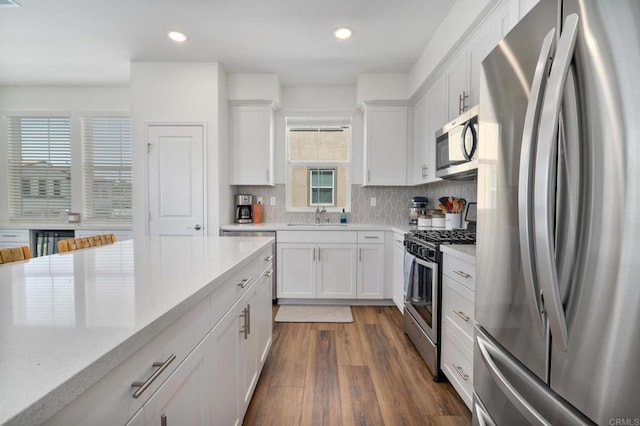 2328 Stardust Gln, Escondido, CA 92025 - kitchen with stainless steel appliances, white cabinets, tasteful backsplash, dark wood finished floors, and recessed lighting